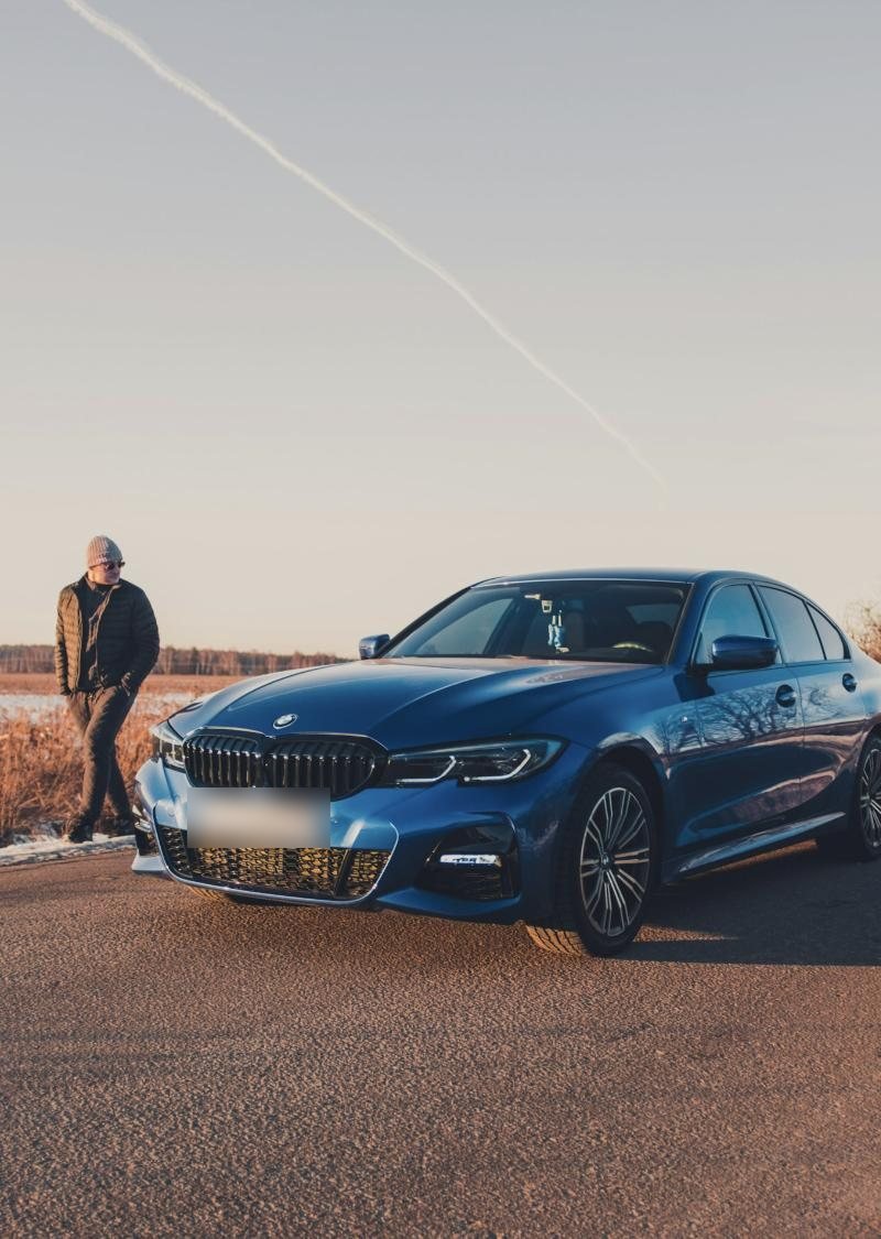 Owner standing by his blue BMW 3 Series